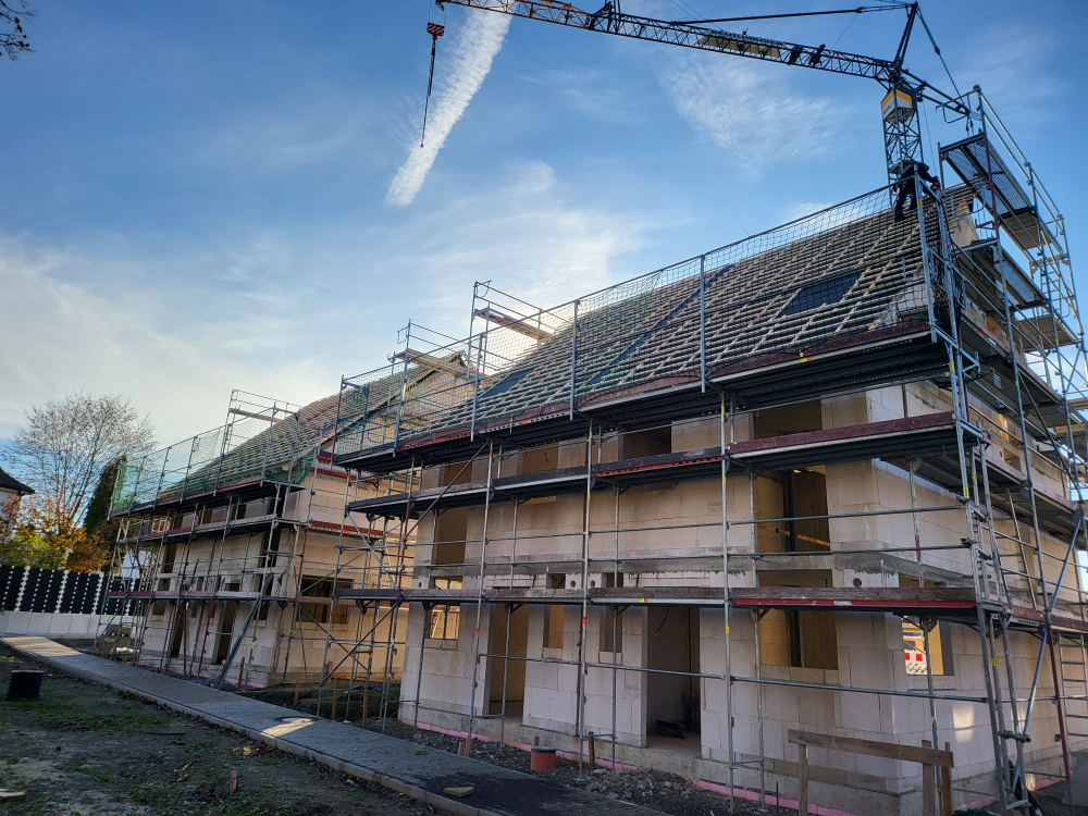 Rohbau mit eingedecktem Dachstuhl und Gerüst